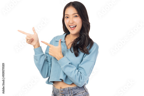 Beautiful young Asian woman pointing up to copy space and looking at camera with smile face and happy Pretty girl act like a satisfied product, use for advertising