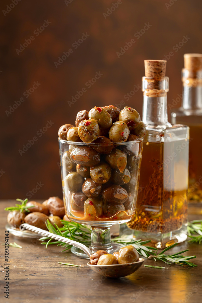 Φωτογραφία Spicy olives and bottles of olive oil on a wooden table.