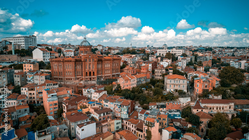 Photo of Fener Greek High School (Red School) taken from the front with a drone. The school was photographed in all its glory with the clear blue sky surrounded by buildings. Balat, Turkey.