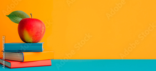 Education colorful mockup with apple on pile of books on yellow background with copy space. Minimalist scholastic composition with study material. photo