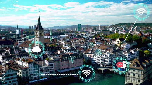 A city view with a clock tower in the center. The city is full of buildings and has a lot of people walking around photo