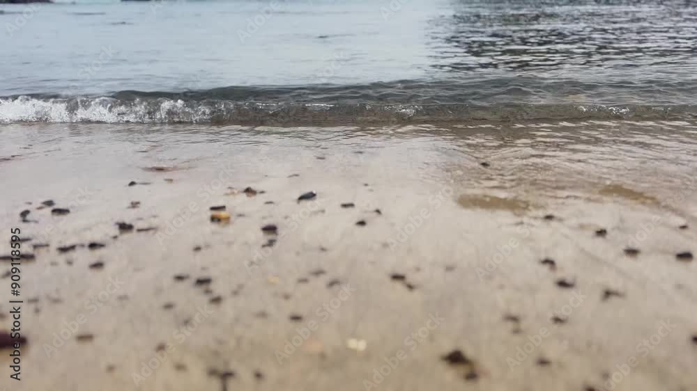 Small waves breaking against part of the sandy beach with volcanic rocks Small waves breaking against part of the sandy beach with volcanic rocks