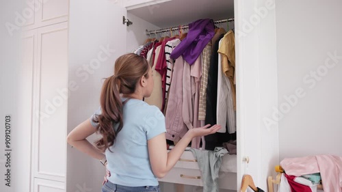 Asia woman people anger shock sad tired used dirty heap clothes neat arrange clean house room. Asian wife home chores open dresser rack look at old closet stack fabric garment fast fashion waste issue