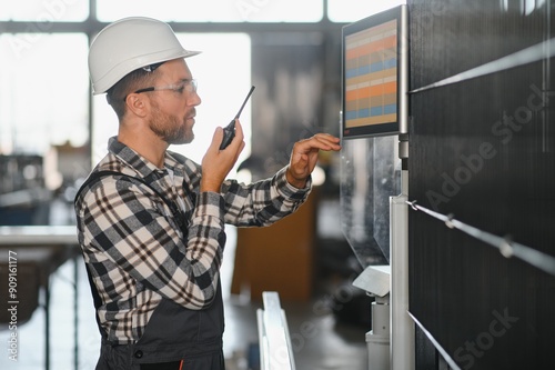 Factory male bearded worker is programming a CNC milling machine with copy space