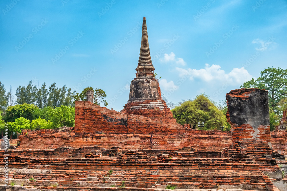 Fototapeta premium Historical Buddhist pagoda on archaelogical site in Ayutthaya historical park Wat Mahathat temple, Thailand. Ancient red brick stupa in Asia. Ancient architectural and cultural heritage