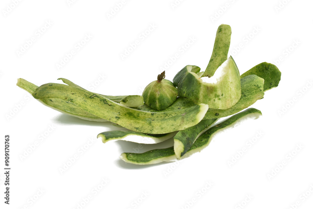 Obraz premium Peeled green peel of cucumbers lies on a white background.