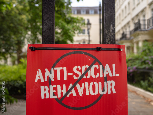 Red sign ANTI-SOCIAL BEHAVIOUR crossed out, urban setting.