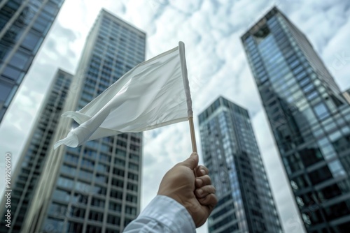 A person stands in front of tall buildings, holding a white flag