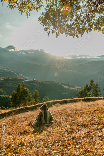 persona de espaldas viendo hacia el horizonte frente a una montaña en un amanecer  photo