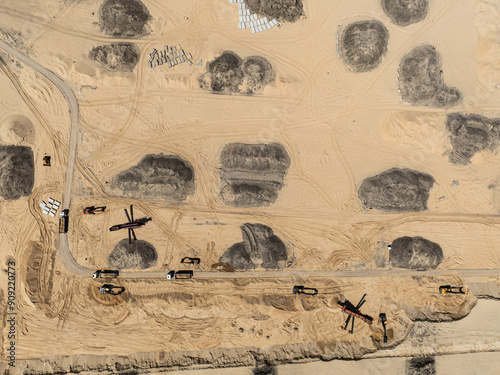 Aerial drone view of a sand mine in the forest. Loader Loading Sand Into Dump Truck In Sand Pit. Quarrying sand. Machines and truck working on sand mine. Mining quarry open pit excavation sand mine. photo