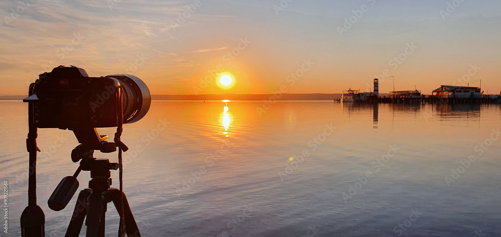 Photographer is taking photo of famous lighthouse on the Podo beach in Neusiedler See during sunset. Tourist attraction of Podersdorf am See. Burgenland, Austria. Photographer is taking photo of famous lighthouse on the Podo beach in Neusiedler See during sunset. Tourist attraction of Podersdorf am See. Burgenland, Austria.