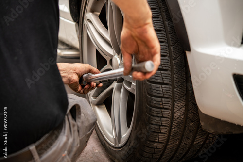 Obraz na plátně Skilled Mechanic Changing a Tire with a Wrench to Ensure Vehicle Safety and Perf