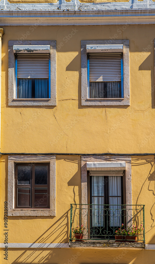 Obraz premium Yellow facade with large windows and balconies. Lisbon, Portugal