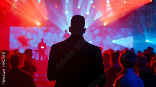 Silhouetted crowd at a vibrant concert with colorful stage lights