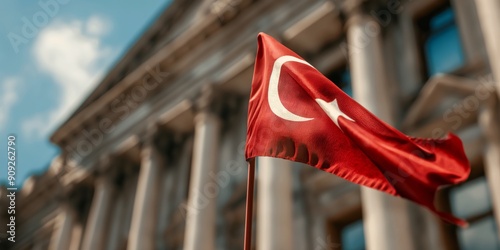 Turkish Flag Waving Proudly: A red and white Turkish flag flutters proudly in the wind against a backdrop of a majestic government building, capturing the essence of national pride and patriotic spiri photo