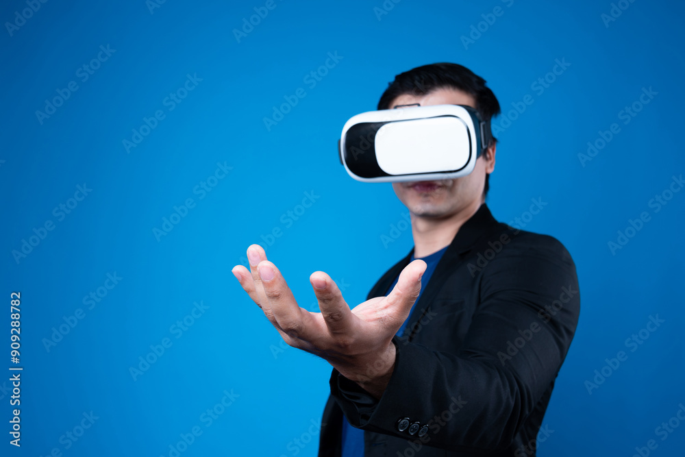 Profile of businessman wearing VR device connecting metaverse, holding stuff in the air isolated blue background futuristic analytics communication technology virtual reality copyspace. Contrivance. Profile of businessman wearing VR device connecting metaverse, holding stuff in the air isolated blue background futuristic analytics communication technology virtual reality copyspace. Contrivance.