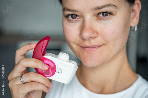Close up view of woman holding medicine dry powder inhaler for treatment asthma or COPD diseases. Pharmaceutical product is used to treat lung inflammation and prevent asthma attack. photo