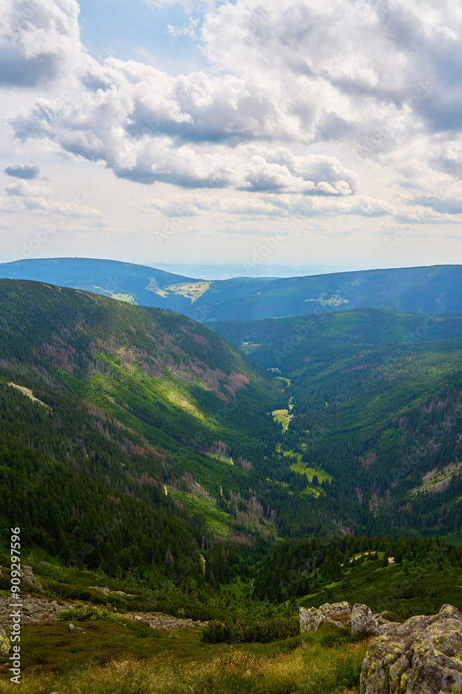 Beautiful panoramic view of green mountain valley with rolling hills and dense forests under cloudy sky. Travel tourism and hiking concept Beautiful panoramic view of green mountain valley with rolling hills and dense forests under cloudy sky. Travel tourism and hiking concept