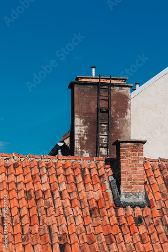 roof section with red tiles and chimney stack photo