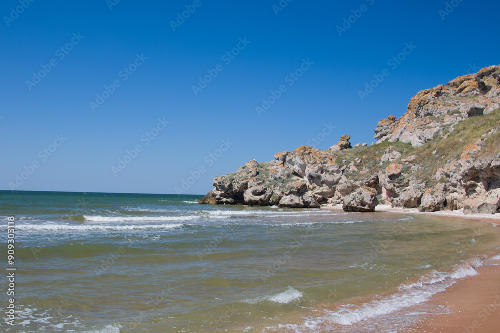 foaming waves on a sandy beach. Seascape with rocks and stones in the water foaming waves on a sandy beach. Seascape with rocks and stones in the water