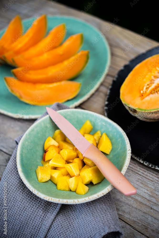 table with bowl with cut peach pieces and melon slices on top. selective focus table with bowl with cut peach pieces and melon slices on top. selective focus