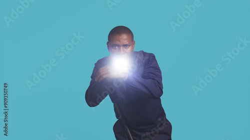 Portrait of security staff member tasked with evicting trespassers turns on flashlight. Patrolling agent maintains secure environment with lantern device, spotting people, studio background, camera B