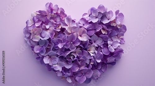 Heart shape made of purple flowers on lilac background. love symbol. top view.