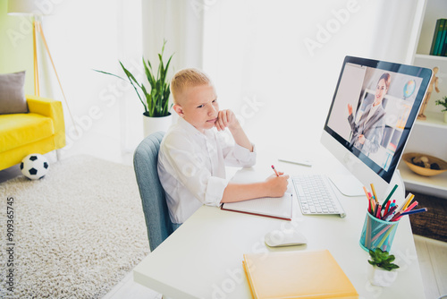 Portrait of adorable clever boy study from home remote listen lesson computer screen indoors room apartment