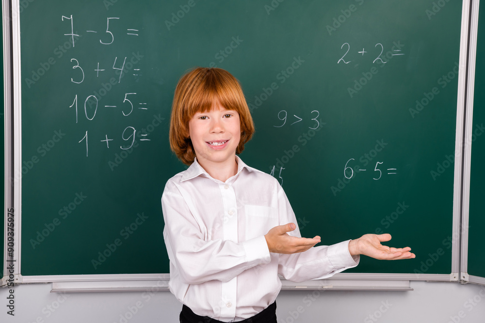 Photo of cute little schoolboy diligent point hands empty space dressed stylish uniform classroom blackboard background Photo of cute little schoolboy diligent point hands empty space dressed stylish uniform classroom blackboard background