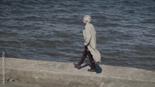 An old man alonely walking on the sea photo