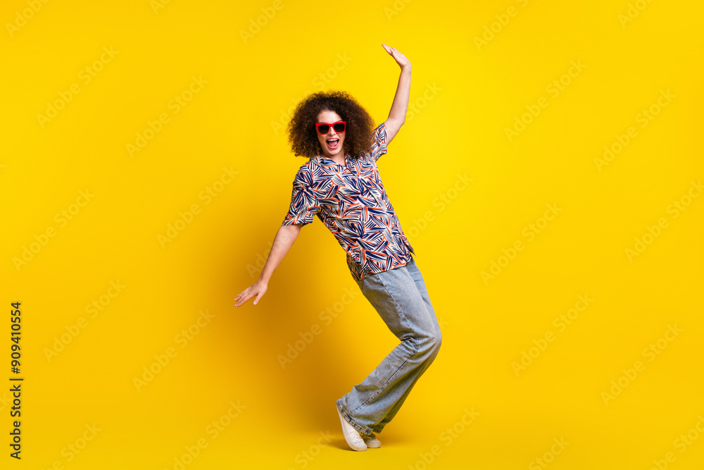 Full size photo of pretty young girl sunglass dance tiptoes wear trendy colorful outfit isolated on yellow color background Full size photo of pretty young girl sunglass dance tiptoes wear trendy colorful outfit isolated on yellow color background