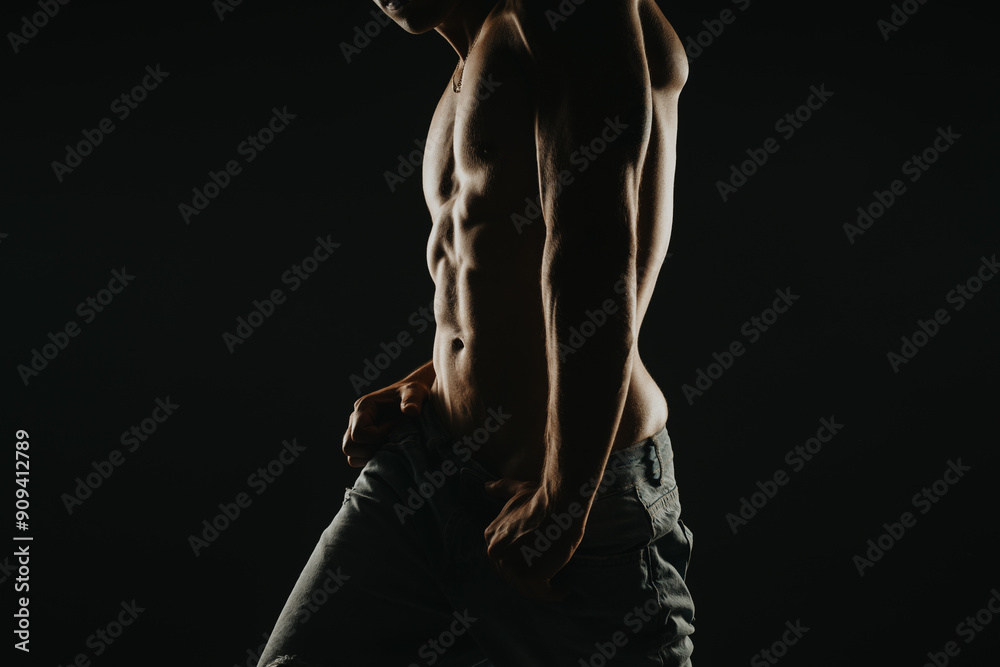 Muscular man with a well-defined torso captured in dramatic lighting, emphasizing fitness, strength, and dedication to physical training. Muscular man with a well-defined torso captured in dramatic lighting, emphasizing fitness, strength, and dedication to physical training.