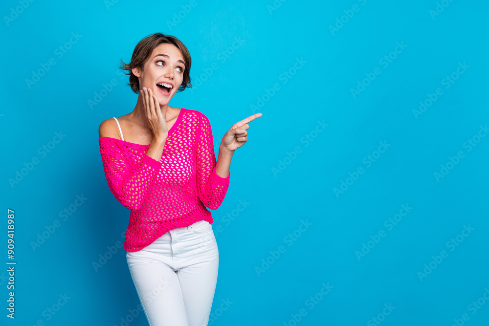 Photo of funky impressed lady dressed knitted pink shirt pointing finger looking empty space isolated blue color background