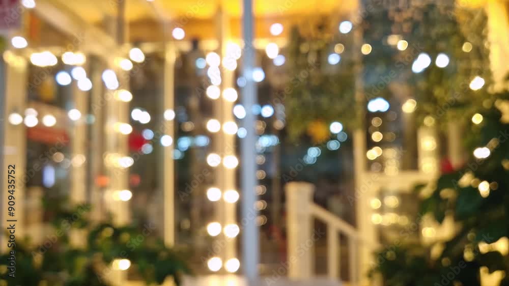 Defocused view outside through the window of a restaurant or cafe with colored decorative lights on the glass
