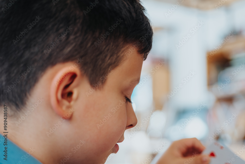 Close-up of a child playing cards at home, engrossed in a fun family activity, photographed in detail. Close-up of a child playing cards at home, engrossed in a fun family activity, photographed in detail.