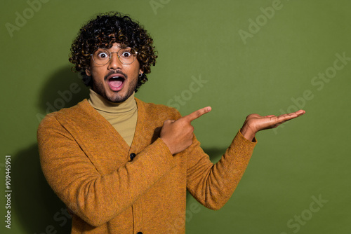 Photo portrait of pretty young male point hold shocked empty space wear trendy brown outfit isolated on khaki color background