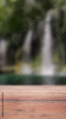 Close-up empty wooden podium with blurred garden waterfall vertical background for product promotion