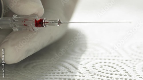 A syringe filled with red liquid is being used to inject a patient