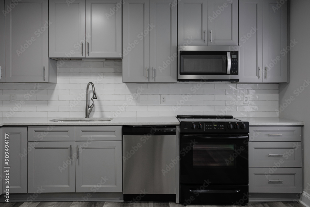 Fototapeta premium Modern Kitchen With Grey Cabinetry And Stainless Steel Appliances