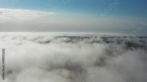Scenic aerial view above dense white clouds during morning sunrise, Latvia