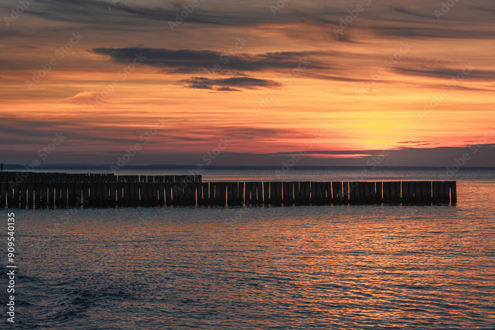 View of sand beach with wooden breakwaters on the Baltic Sea coast on sunset in Zelenogradsk. Russia