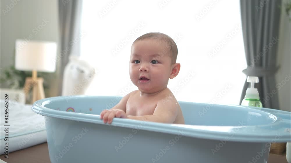 A tiny child enjoys taking a bath in a baby bathtub A tiny child enjoys taking a bath in a baby bathtub