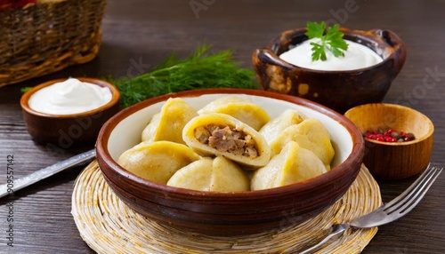 Flavorful Kolduny: Belarusian Dumplings Filled with Meat or Potatoes, Served with Sour Cream photo