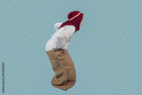 Side view of Indonesian woman in a gunny sack for Indonesian Independence Day competition. photo