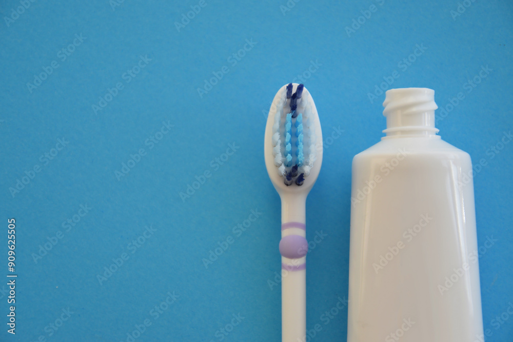 Toothbrush with toothpaste on blue paper background Toothbrush with toothpaste on blue paper background