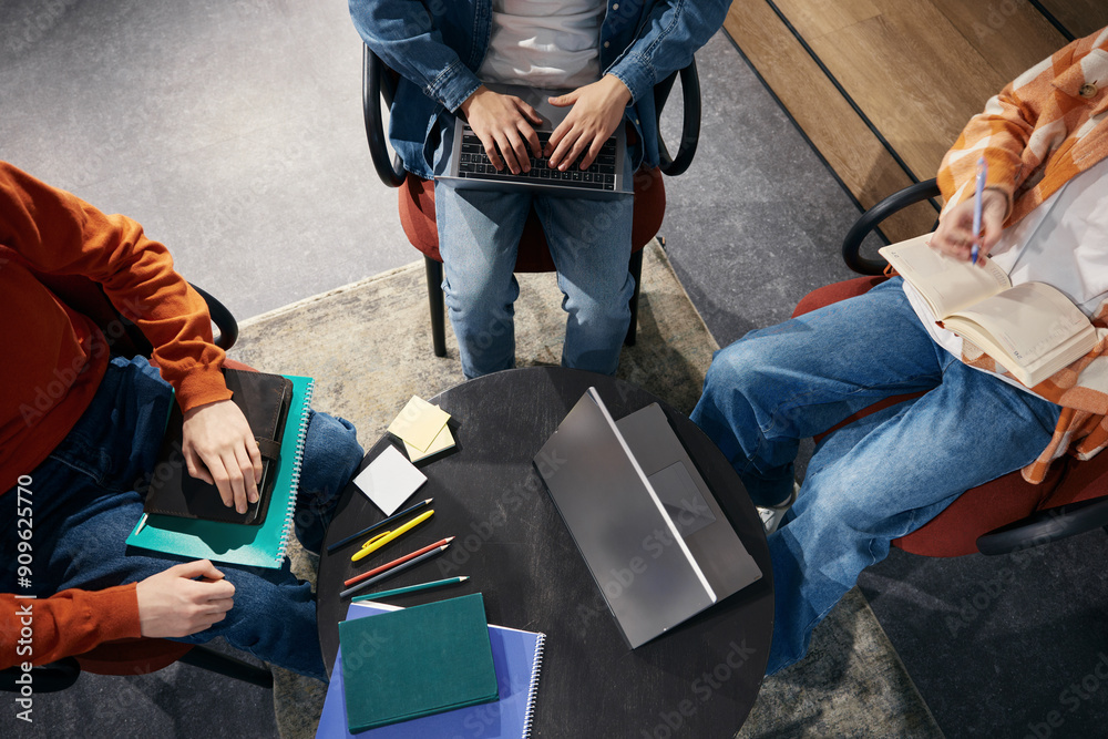 Fototapeta premium Three people working using laptops in office above view