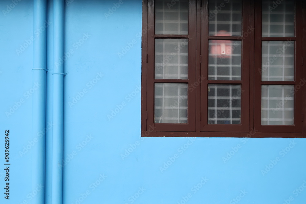 Obraz premium A normal household in Kerala with blue wall and simple wooden window design