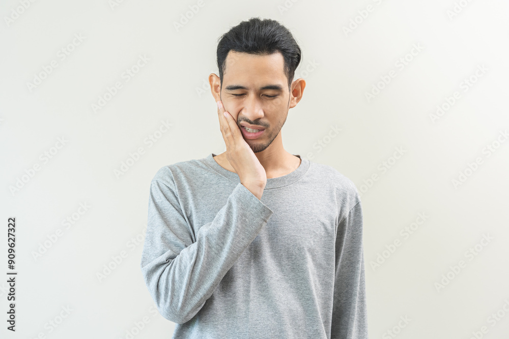 Portrait of male face suffering from sensitive teeth, tooth pain asian young man feeling hurt hand touching cheek and mouth. Health care, medicine of toothache. Dental decay problem, dentist treatment Portrait of male face suffering from sensitive teeth, tooth pain asian young man feeling hurt hand touching cheek and mouth. Health care, medicine of toothache. Dental decay problem, dentist treatment