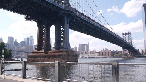 New York City Manhattan Bridge, Brooklyn Dumbo USA. Waterfront Manhattan downtown cityscape, financial district skyscraper skyline. Riverfront John street park promenade under bridge, East River. photo