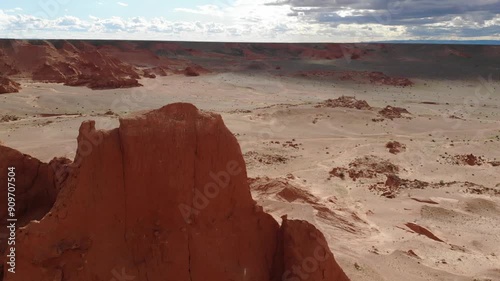 The Flaming Cliffs in the Gobi Desert, Mongolia, under a clear blue sky, showcasing its iconic red sandstone formations and barren landscape.